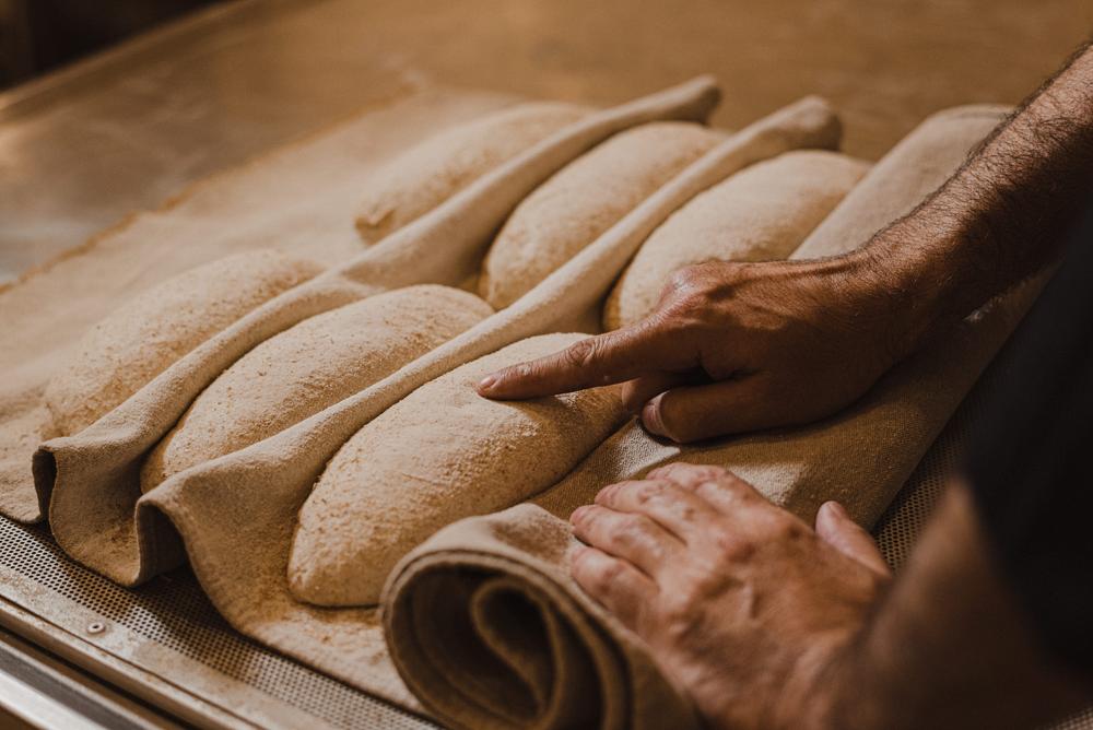 Mãos verificando pães no couche